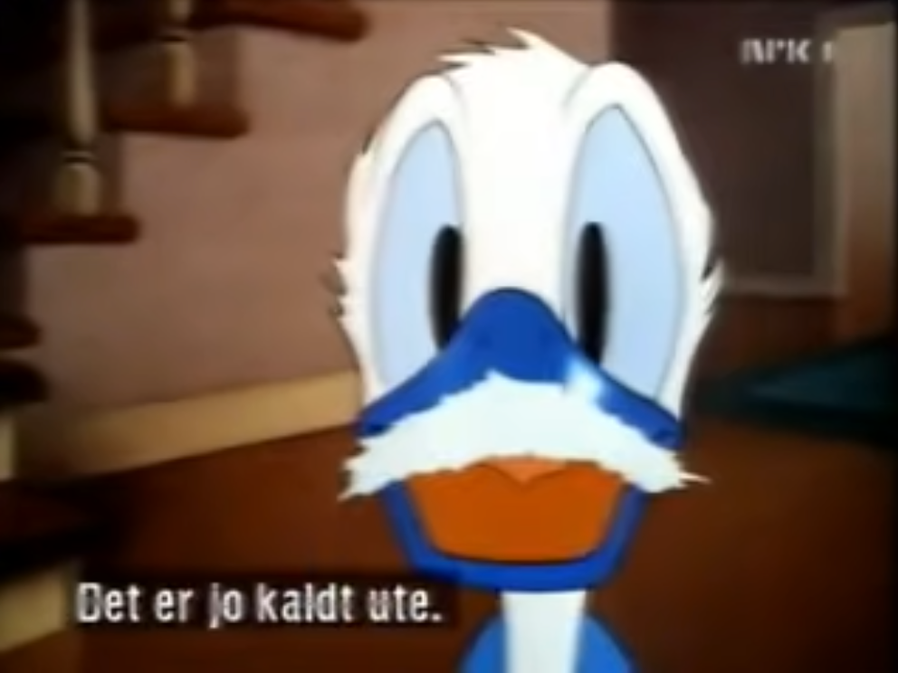 Donald Duck with a snow mustache on his frozen blue bill. Subtitles in Danish read "Get er jo kaldte ute"
