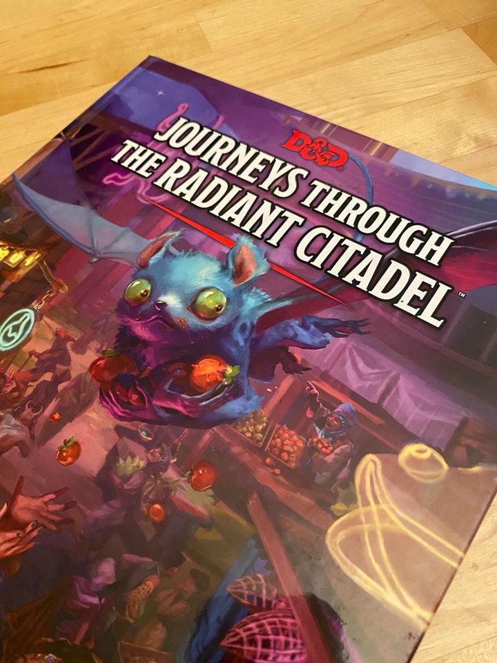 A copy of Journeys Through the Radiant Citadel on a wooden table