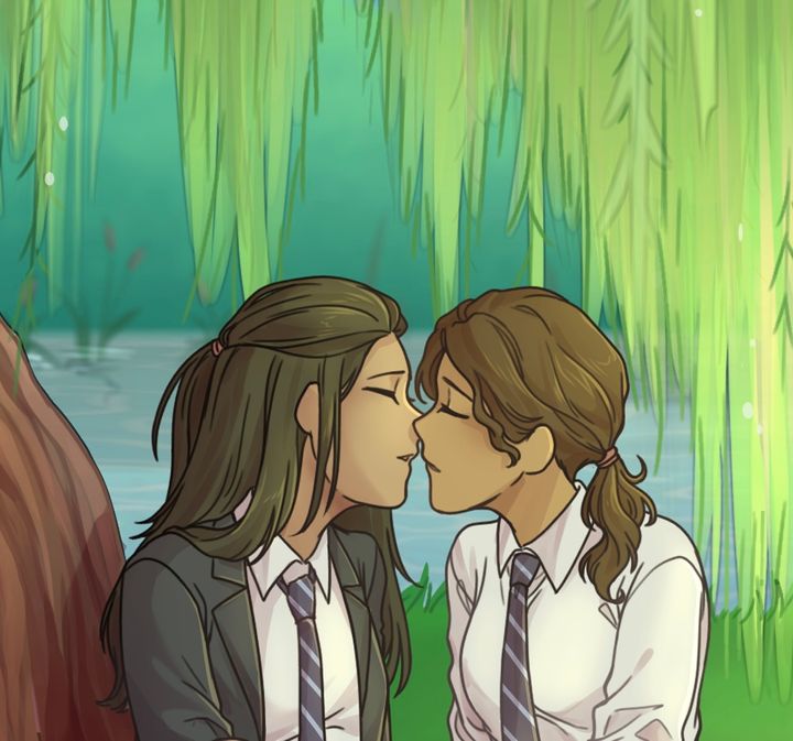 Closeup of two girls in school uniforms about to kiss under a willow tree.